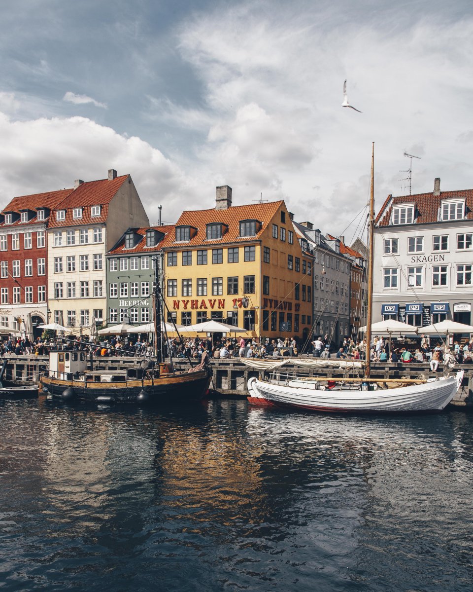 VisitCopenhagen's tweet photo. The #summertime vibe is real in #Nyhavn - probably the most well-known &amp; colourful street in #Copenhagen https://t.co/TA74wm4O2m