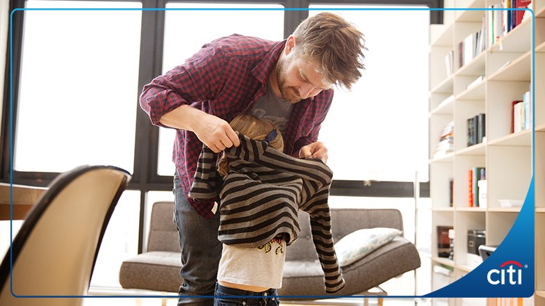 Father helping a son get dressed. 