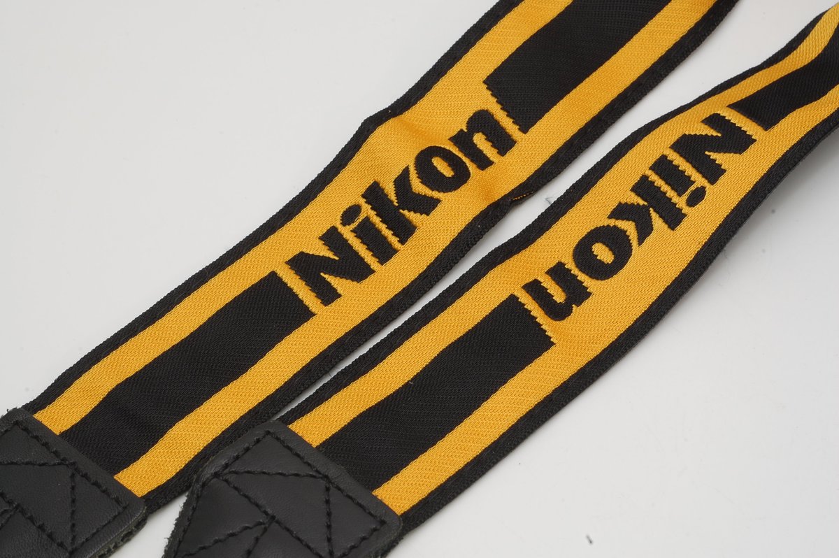 このデザインの ニコンストラップには、 フィルムカメラの NIKON FE を