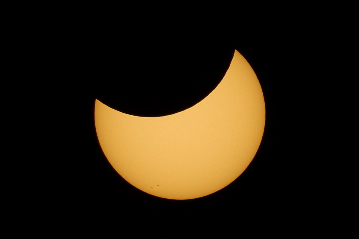Moon covering upper third of sun