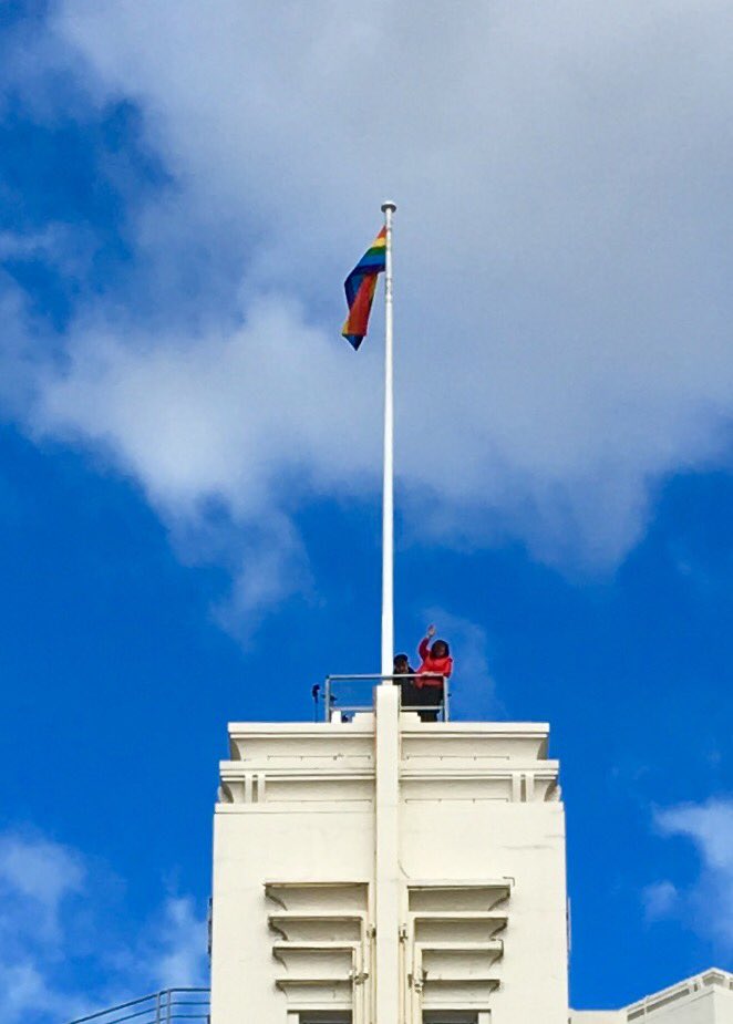 RonChristie's tweet photo. Lord Mayor Sue with Rodney Croome &amp; Susan Ditter raise the Rainbow Flag on Council building as onlookers at St Davids Park applaud &amp; cheer https://t.co/ARPM5wM3LM