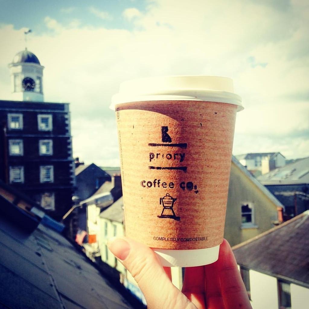 PrioryCoffeeCo's tweet photo. Super shot of a Priory cup over the Youghal skyline &amp; #youghalclockgatetower for #priorycuptourdecork by @shar_murf https://t.co/OcgyuJyZhy