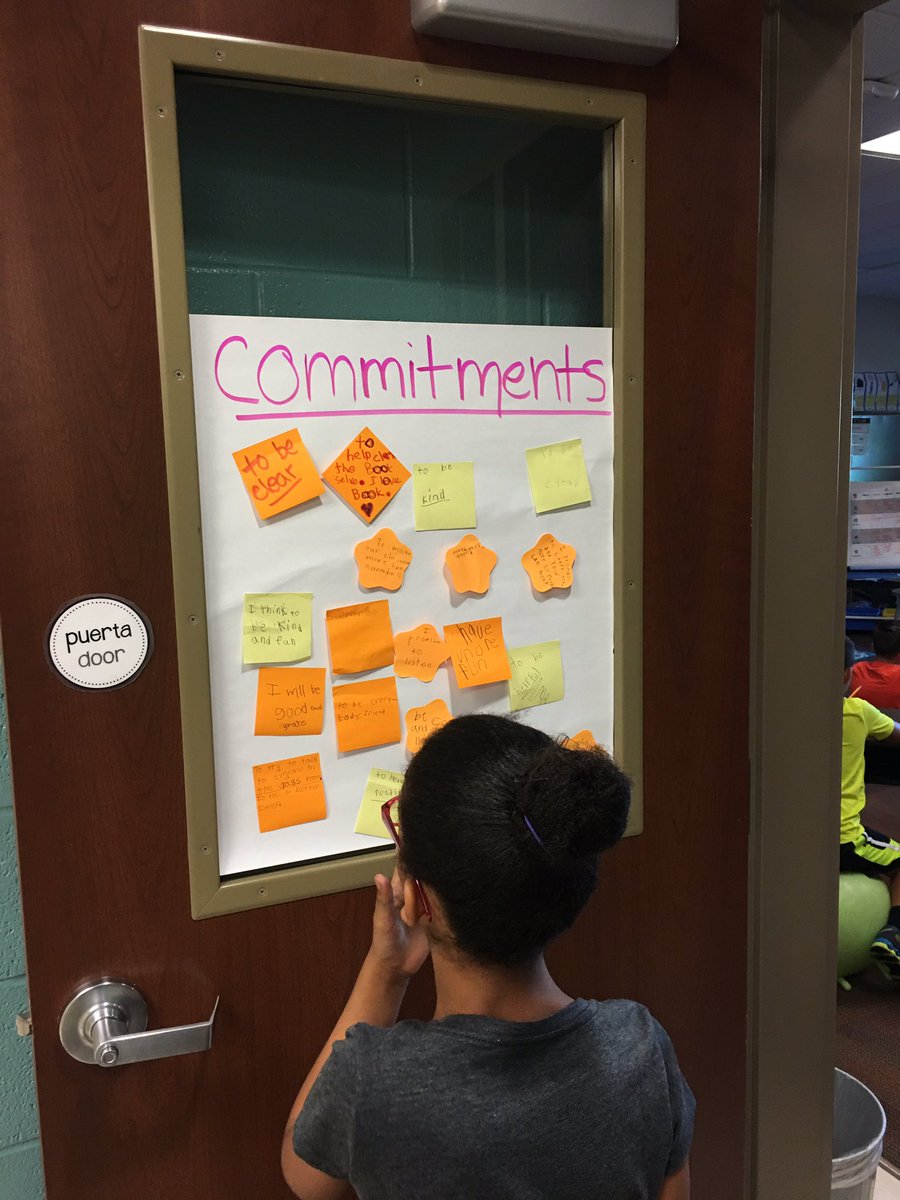 Students creating and reviewing commitment cards during morning meeting.
