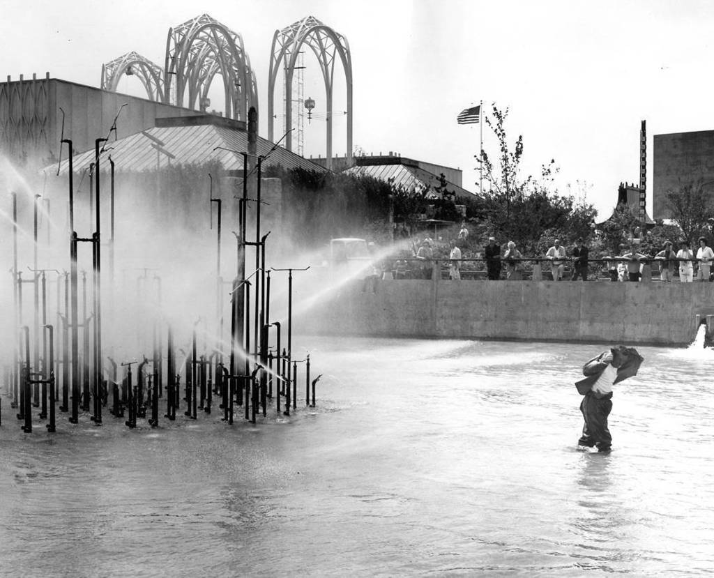 Original caption: "Dale Pierce, plumber, pulls rubber jacket over his head as he walks away from spray from new Ce… ift.tt/2uM2R7U