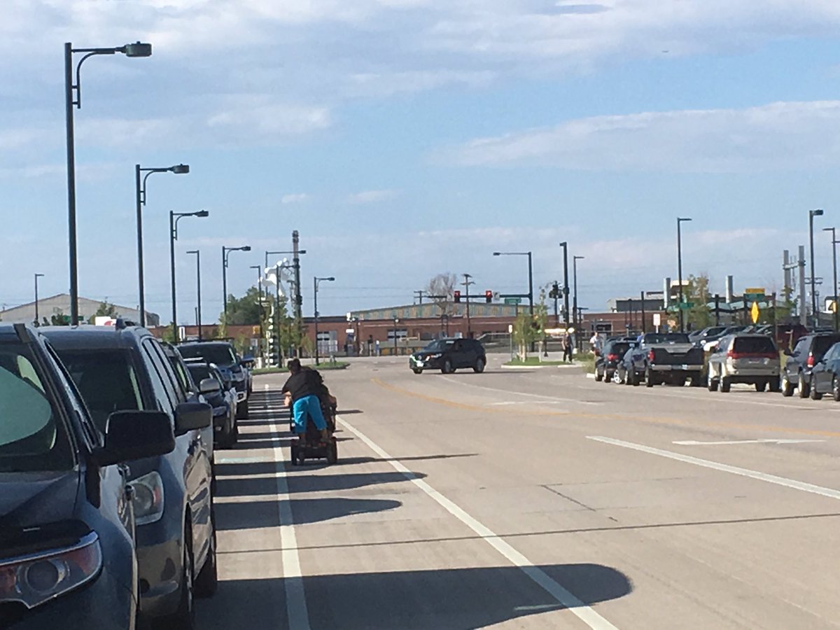 perkja's tweet image. Woman using a power wheelchair and child forced to use bike lane 1 block from brand new station bc there are no sidewalks #streetfail