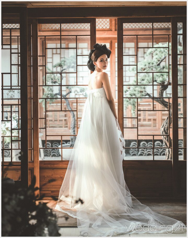 [서담화 한복] 순백의 한복 드레스가 여성스러우면서 청초한 분위기를 자아낸다. 
출처: 한옥과 한복, 그 아름다운 조화, 서담화 - wef.co.kr/bbs/board.php?…