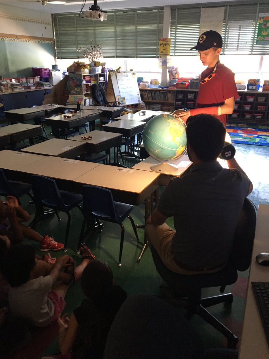 Gavin,a CPS high school student, teaches first graders about the eclipse