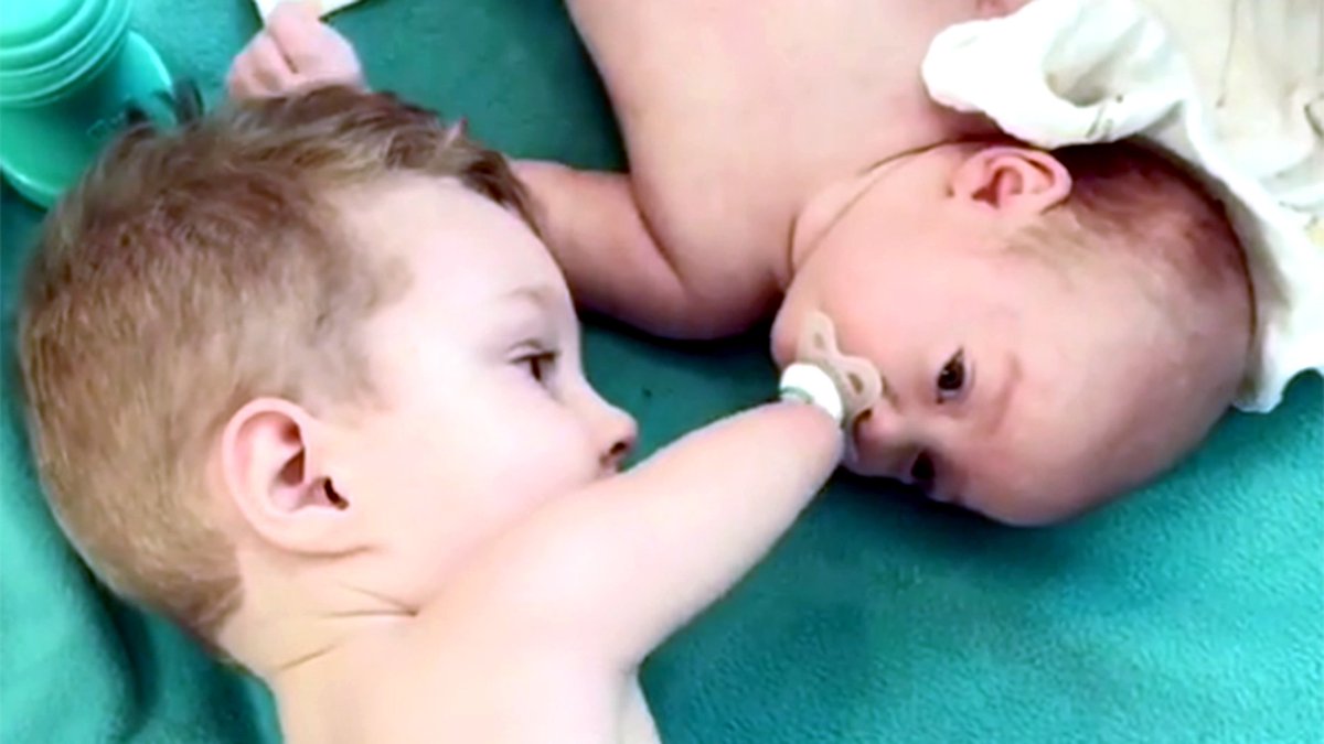 TODAYshow's tweet photo. Hey, Ma, I got this! Watch toddler without arms help baby brother with pacifier https://t.co/GAq6HOQKD4 https://t.co/5pLGa81Ogn