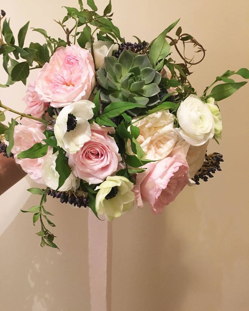 A bridal bouquet full of David Austin roses, anemones, ranunculus, jasmine and succulents all tied off with a beautiful silk trailing ribbo…