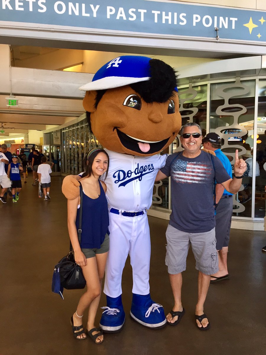 Two people stand next to life sized bobble head