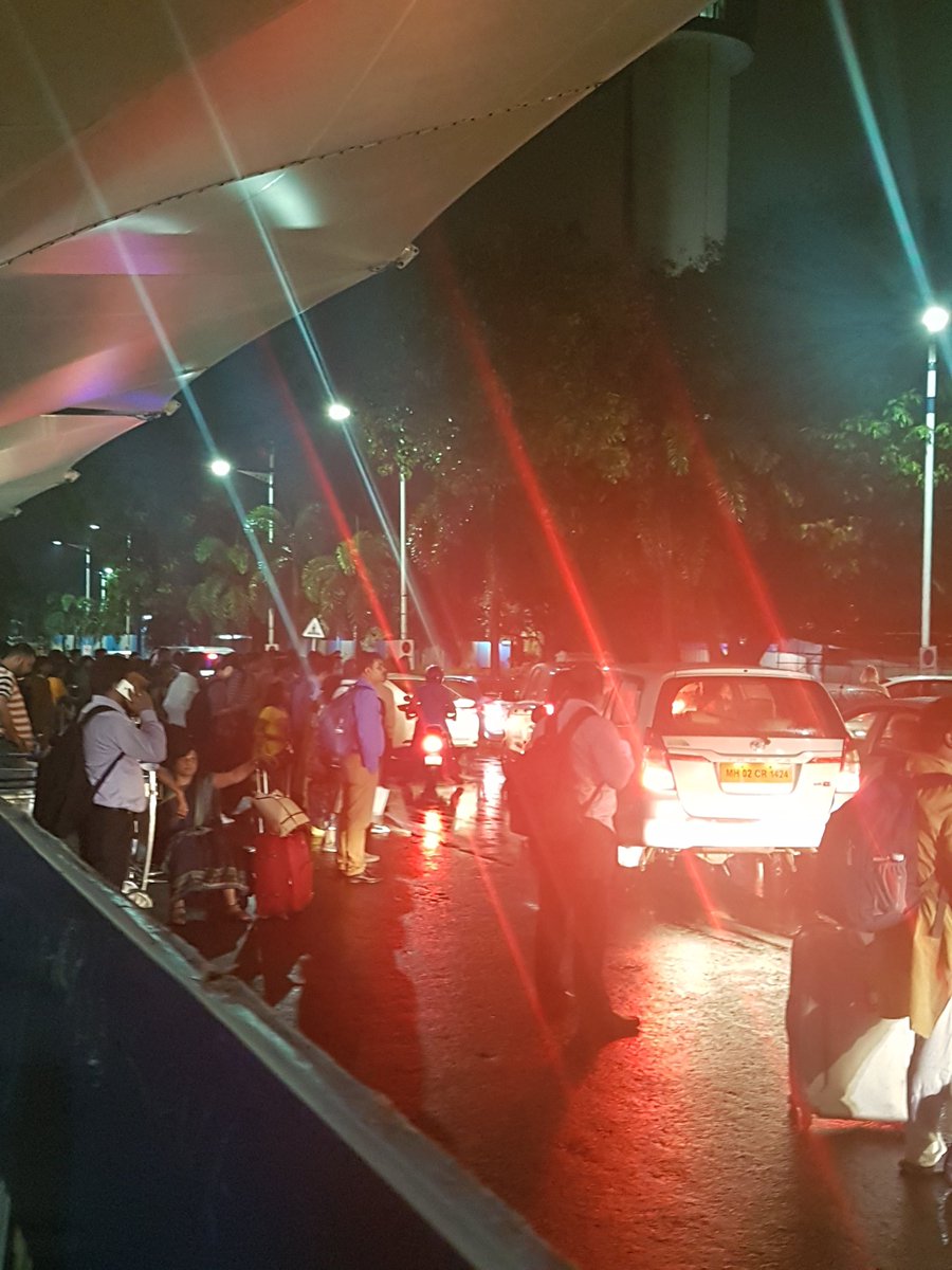 Police assisting folks with cabs and special shuttle services. Outside Mumbai airport's domestic arrival terminal. #MumbaiRains