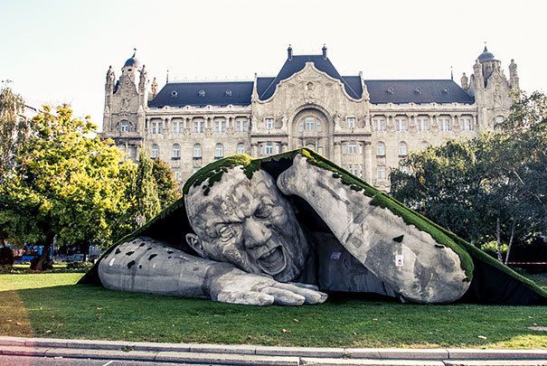 archpng's tweet photo. Giant statue crawls out of the ground in Széchenyi Square, Budapest. Photo by Laslow Barkoni https://t.co/G55T74KtcT