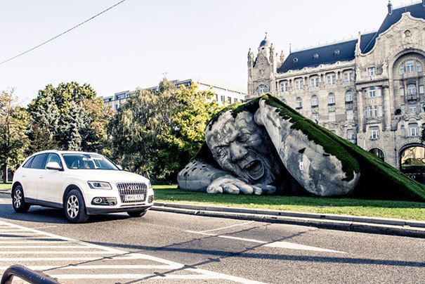 archpng's tweet photo. Giant statue crawls out of the ground in Széchenyi Square, Budapest. Photo by Laslow Barkoni https://t.co/G55T74KtcT