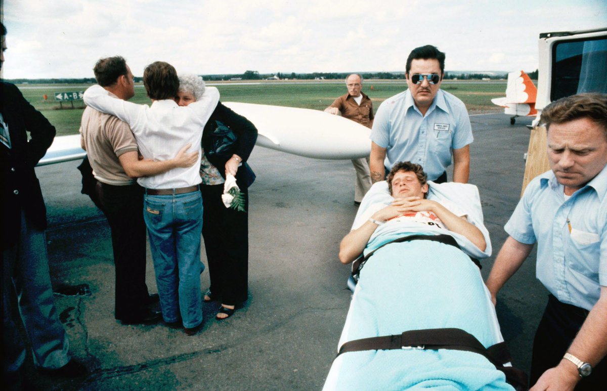 Sept 2, 1980: Terry Fox's parents are embraced by his friend Bill Vigars, of the Canadian Cancer Society, as Terry is wheeled to the plane.