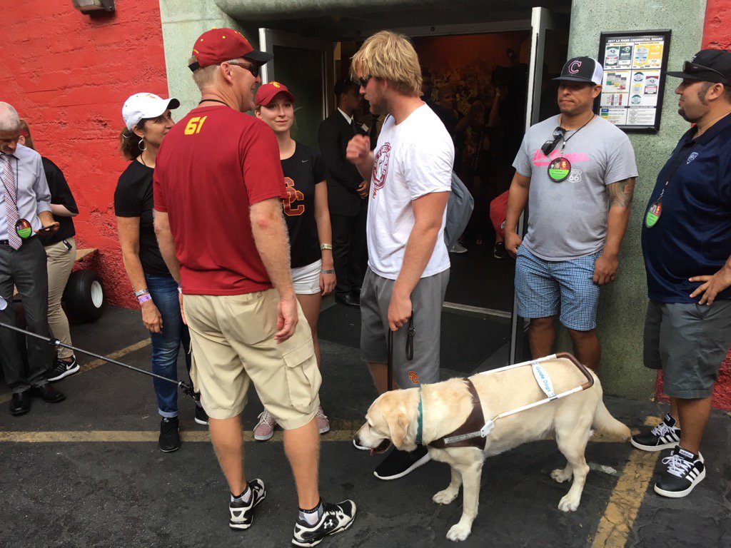 gregbeacham's tweet photo. USC long-snapper Jake Olson greeted after the game by his family and his service dog, Quebec. https://t.co/ma2r1uj2BB