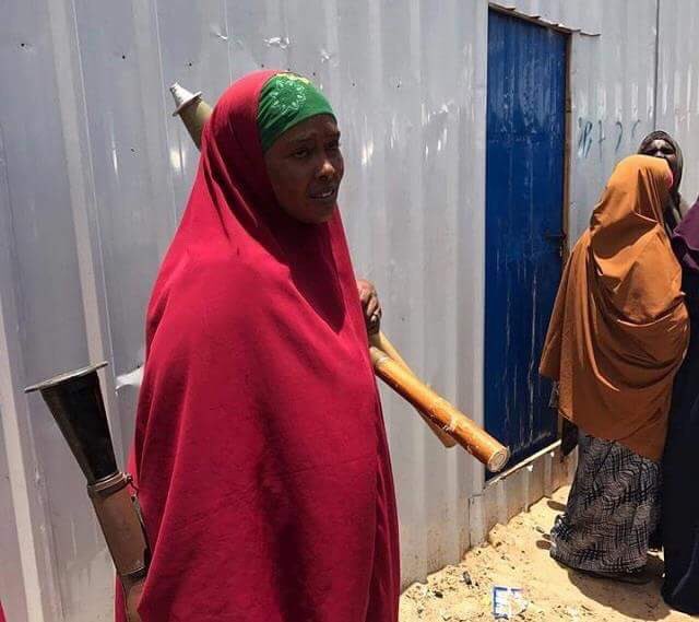 Yassinjuma's tweet photo. A civilian woman in Mogadishu takes up an RPG from a fighting soldier to mediate btwn 2 rival troops within Somalia Army.10 soldiers killed https://t.co/Q9qmmXzBFq