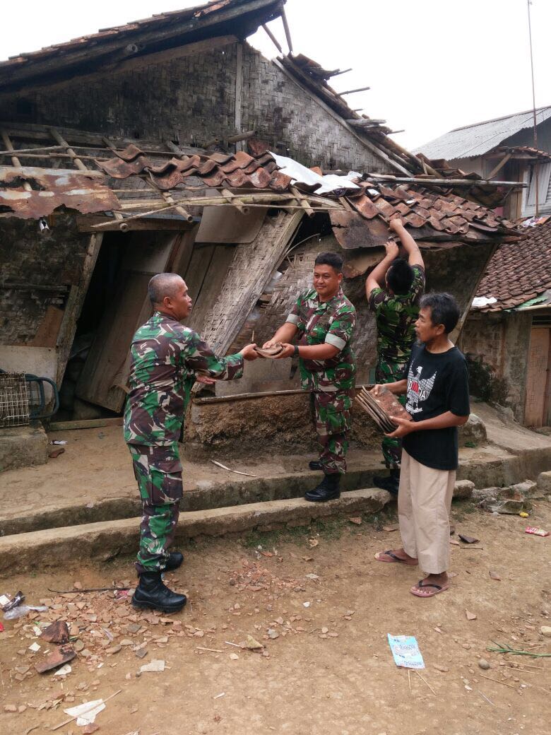 Prajurit TNI sedang gotong royong membongkar rumah Mak Cacih