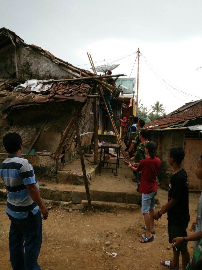 Prajurit TNI sedang gotong royong membongkar rumah Mak Cacih