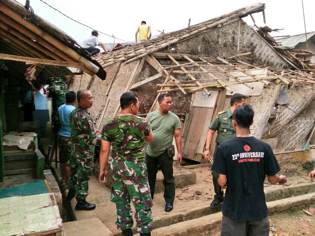 Prajurit TNI sedang gotong royong membongkar rumah Mak Cacih