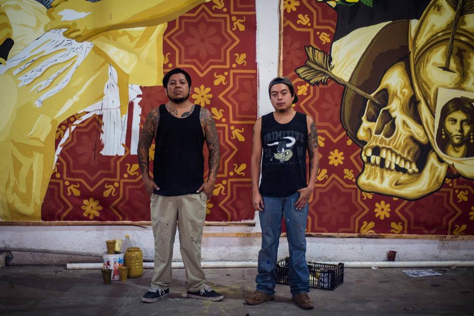 Artists standing in front of canvas