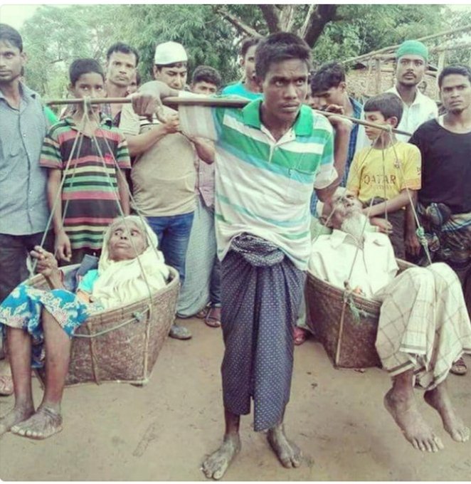 نازح روهنغي يحمل على عاتقه والديه المسنّين بعد ما فر بهما من عمليات إحراق جيش ميانمار لقرى ومنازل الروهنغيا في ولاية أراكان