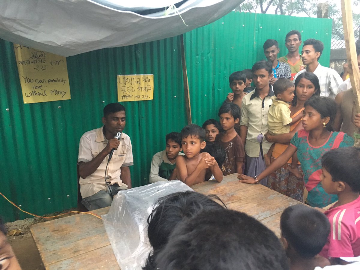 ChrisBoulierac's tweet image. A man with a mic works to reunify separated #Rohingya families in a camp. @UNICEFBD has documented more than 1100 separated children so far.