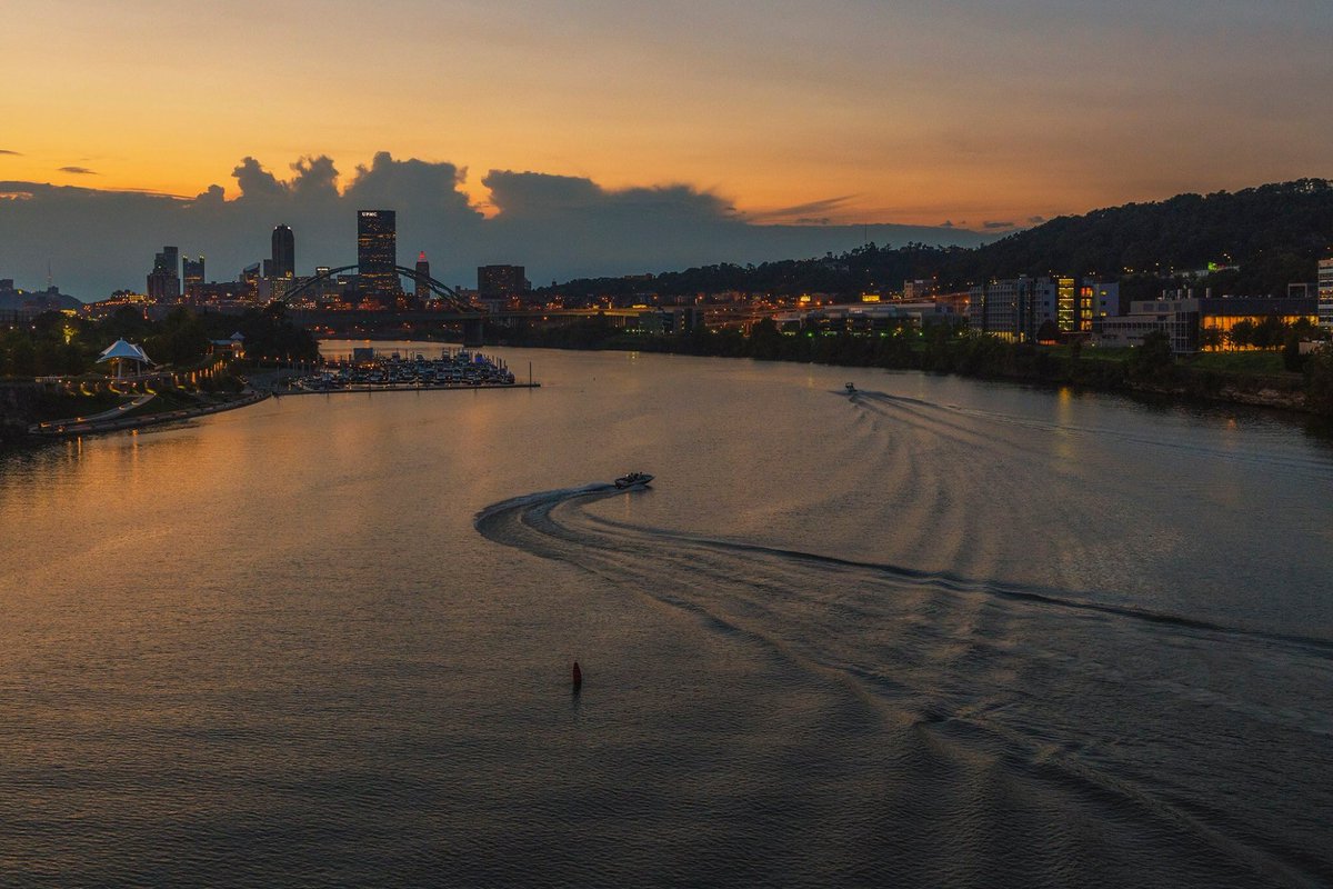 DaveDiCello's tweet photo. A boat meanders along the Monongahela River as a golden sunset backdrops #Pittsburgh in a view from the Hot Metal Bridge https://t.co/LNGHDX7582