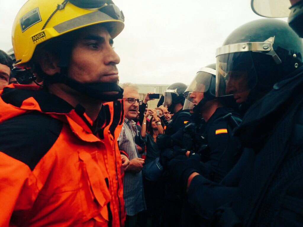ANC_Bombers's tweet photo. The image of the day: Catalan Fire Fighters protecting our people from Spanish military police. #SpainisaDictatorship #CatalonianReferendum https://t.co/H5GtDHYWg2