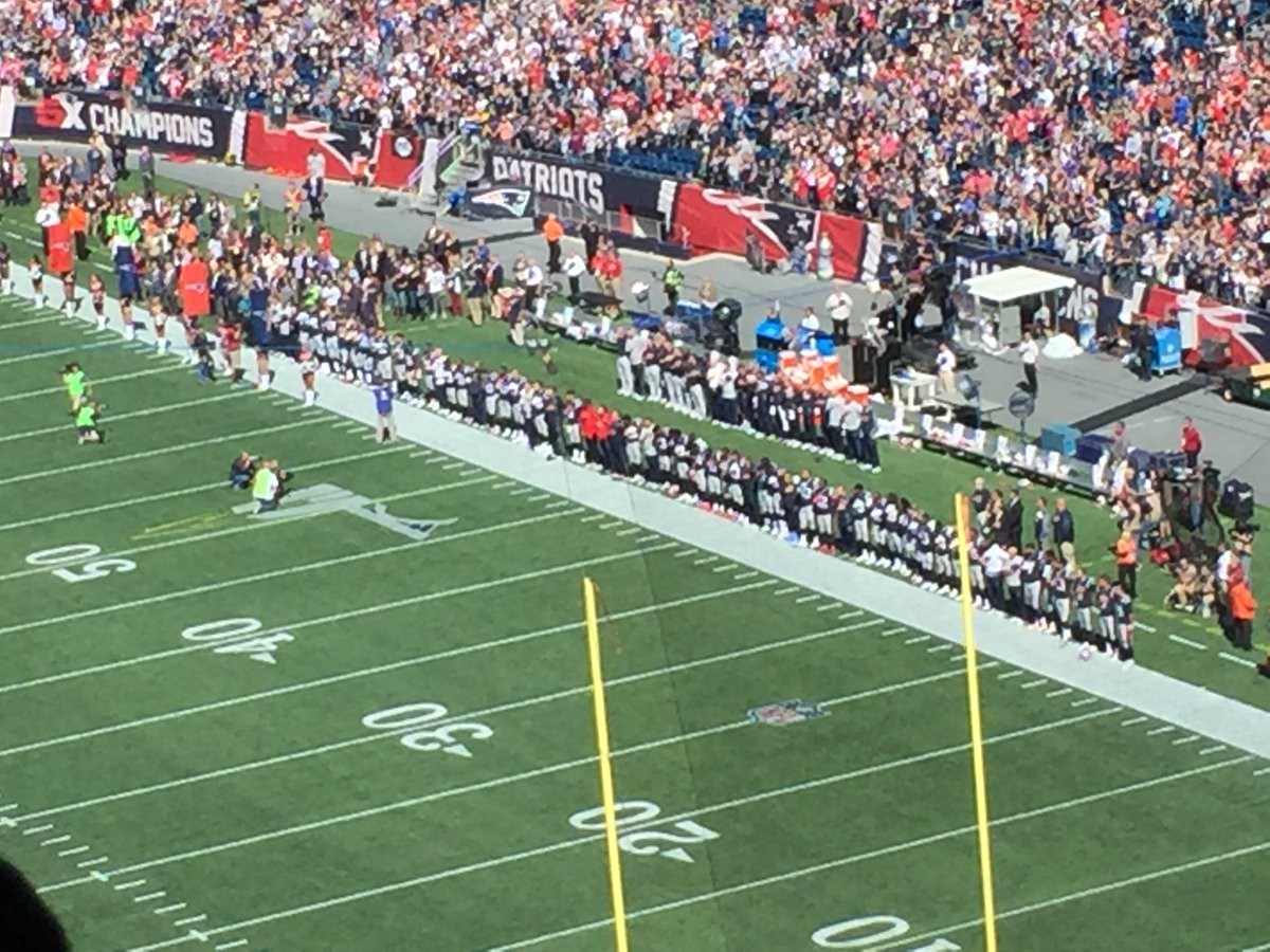 BenVolin's tweet photo. Patriots stood with 1 hand over heart, 1 arm around a teammate. Everyone on Panthers stood. Big cheers from the crowd https://t.co/3kG2EWJo6U