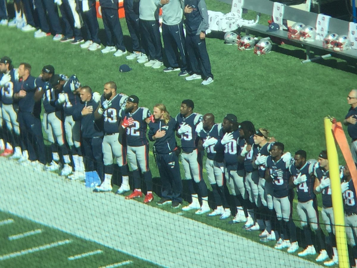 BenVolin's tweet photo. Patriots stood with 1 hand over heart, 1 arm around a teammate. Everyone on Panthers stood. Big cheers from the crowd https://t.co/3kG2EWJo6U