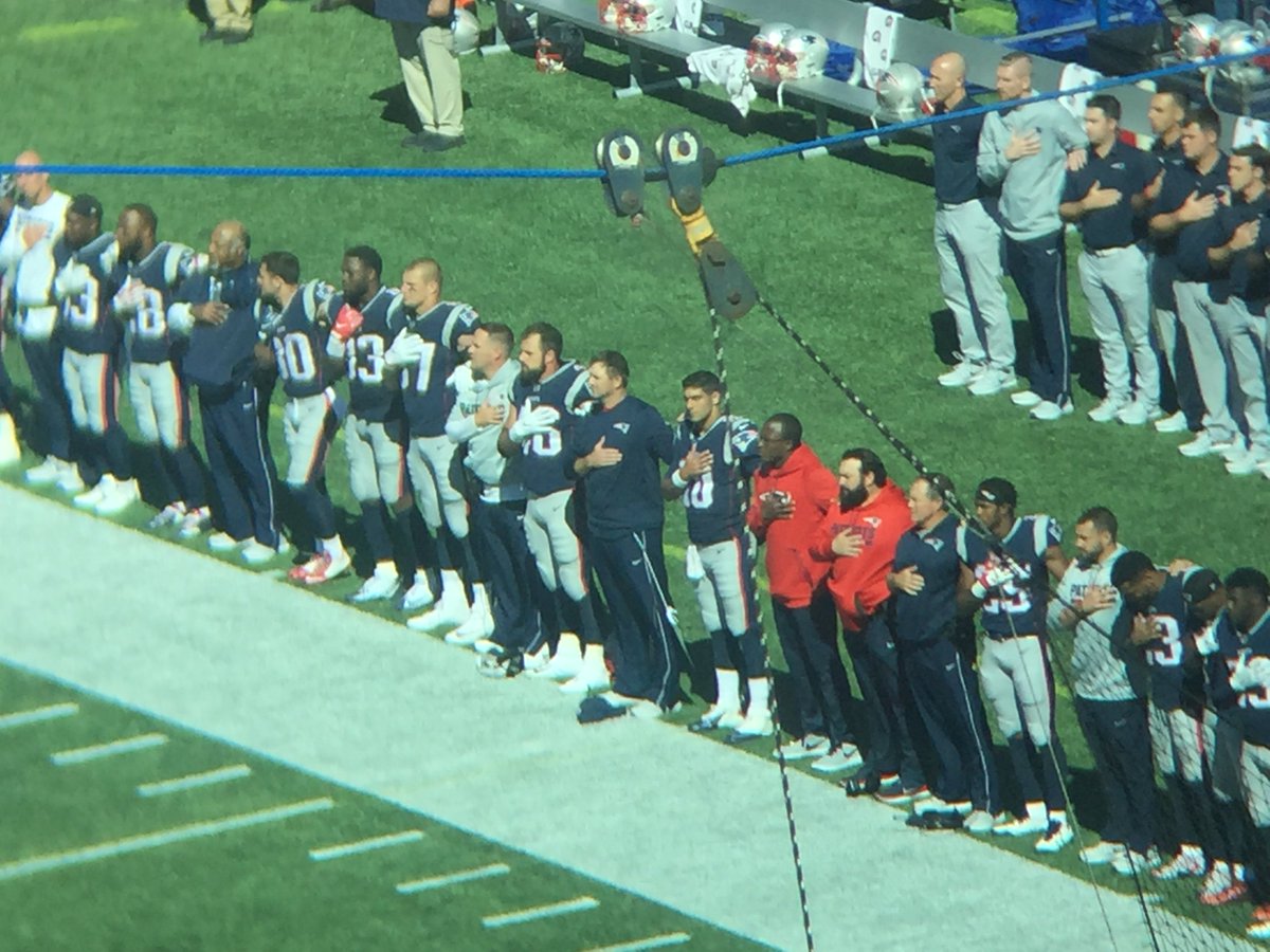 BenVolin's tweet photo. Patriots stood with 1 hand over heart, 1 arm around a teammate. Everyone on Panthers stood. Big cheers from the crowd https://t.co/3kG2EWJo6U