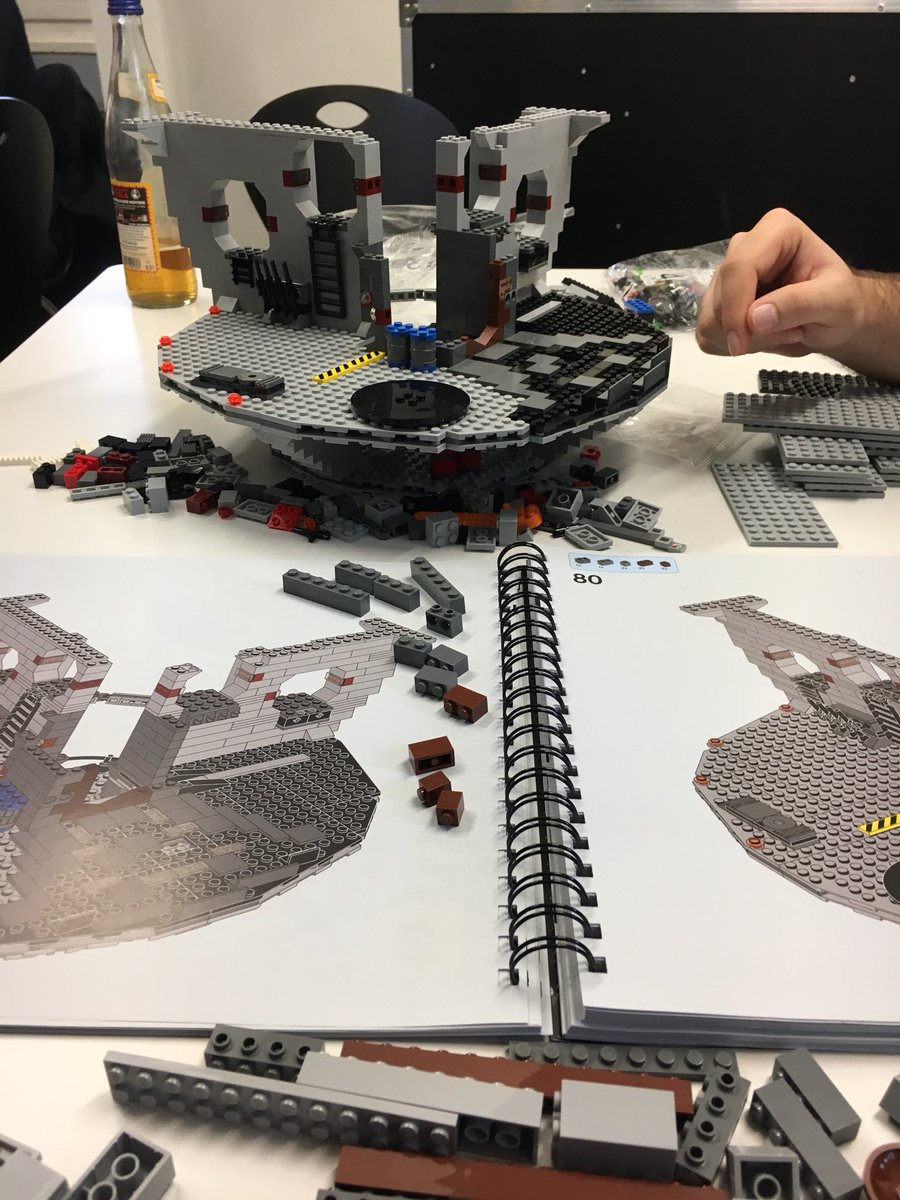People building a Lego Death Star.