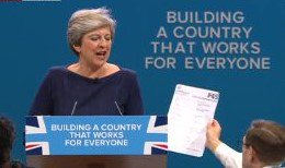 LBC's tweet photo. Prankster Simon Brodkin aka Lee Nelson hands Theresa May P45 as she gives her Conference speech. She says she’ll give one to Jeremy Corbyn. https://t.co/8gH7OZ0zR4