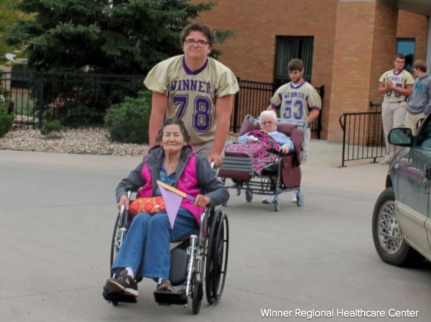 ABC's tweet image. South Dakota HS football players wheel elderly residents out to enjoy homecoming parade. "It’s monumental to them." abcn.ws/2xZIVyZ