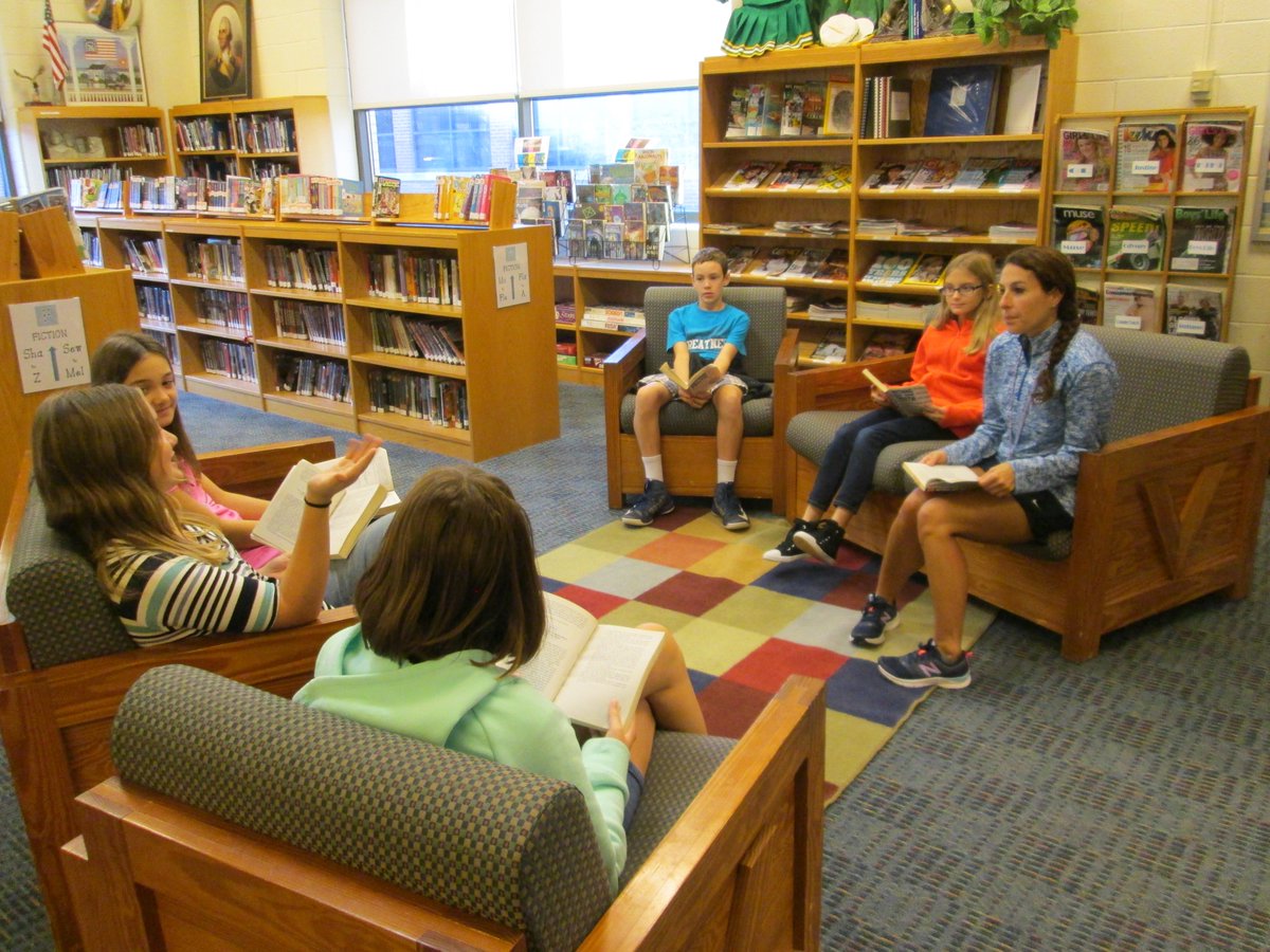 dbelle57's tweet photo. PE teacher Valerie Atlee reading w/6th graders. Has she has given up PE? No way! Showing her "well-read"iness. https://t.co/hBVtiR4XTY