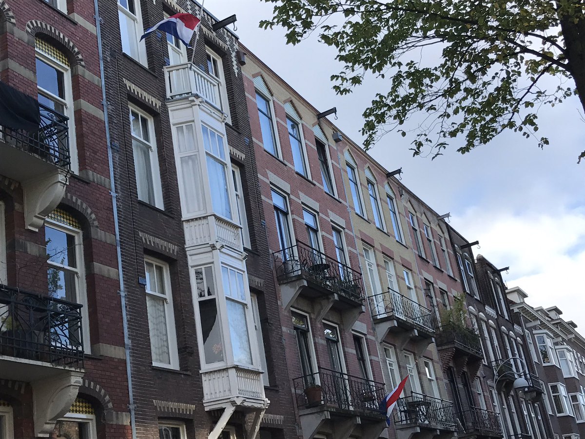 In de straten van Amsterdam hangen de vlaggen halfstok voor de overleden burgermeester.