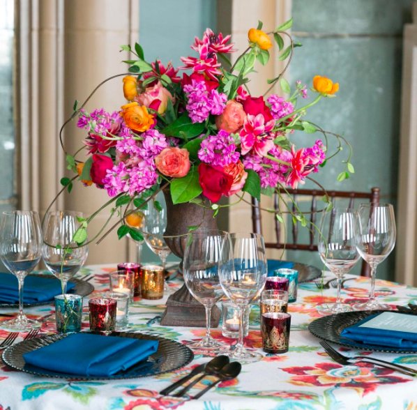 For a fun and festive look, match the colors of your floral centerpiece with a patterned table cloth for lively table decor #EventProfs