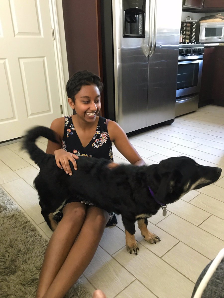 me on the floor of a kitchen, with Pokey the puppy stretched over my lap and leaning toward something out of the picture