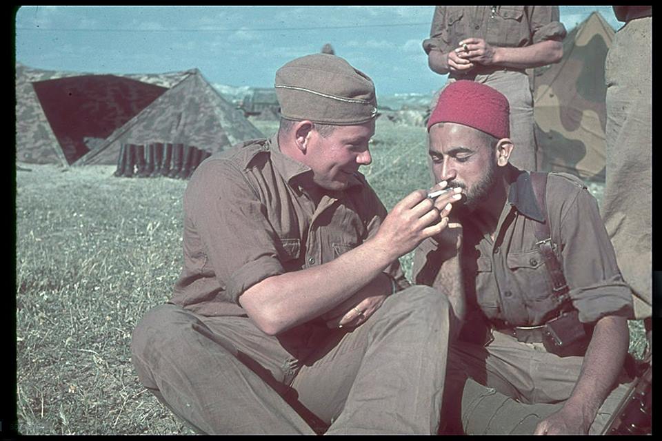 Un soldado alemán de la Legión Cóndor enciende un cigarrillo a un soldado de una unidad marroquí en su campamento, mayo de 1939.