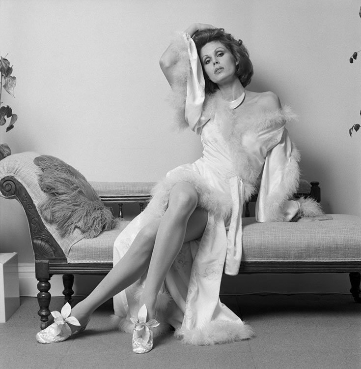 Terry_ONeill's tweet photo. Joanna Lumley wearing a white evening dress and is reclining on a sofa bed. 
She stars as Purdey in ‘The New Avengers’, circa 1977. https://t.co/RQzbnIyyet