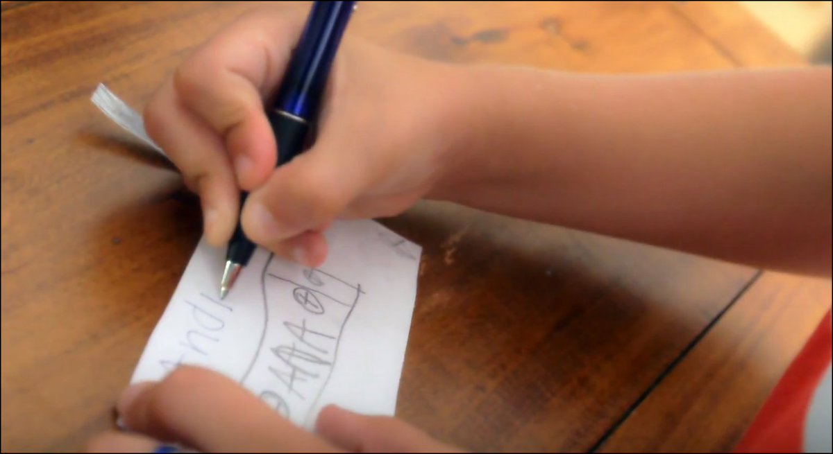 Closeup of Andrew's hands writing on an index card.