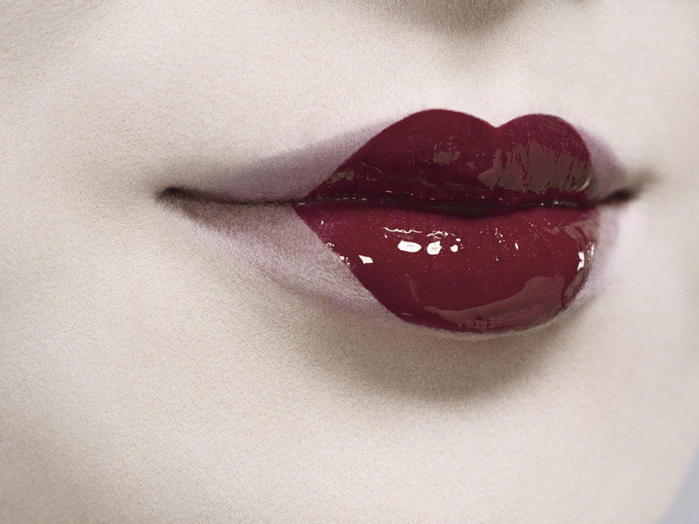 Beestung lip années 20 inspiration. Close-up gros plan lèvres effet bee stung gloss rouge peau très blanche inspiration maquillage années 20.