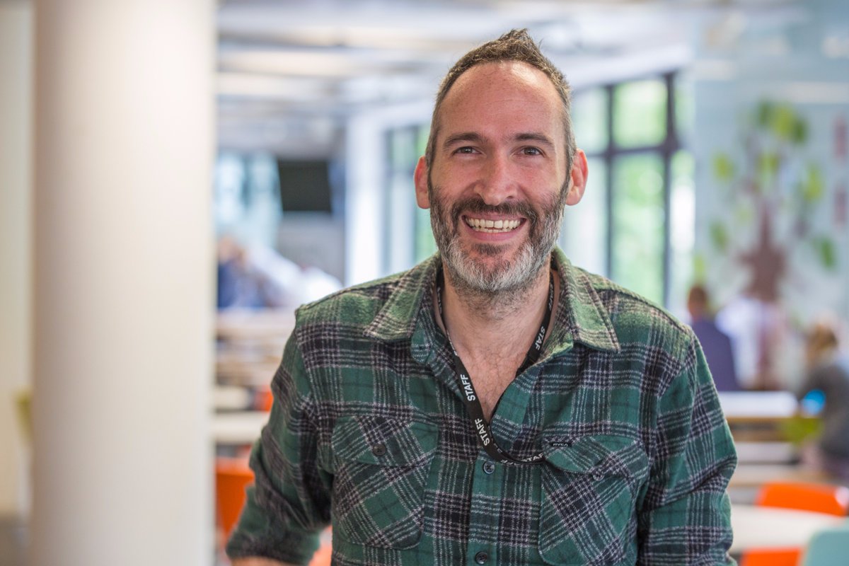 Head shot of man in office smiling at camera