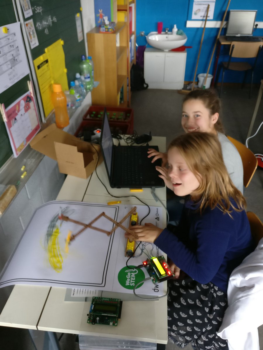 A robot in action. Note that these young ladies are dual-wielding two markers!