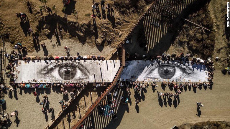 cnni's tweet photo. There was a "giant picnic" at the US-Mexico border featuring an elusive French street artist's "eyes of the dreamer" https://t.co/osZOZTOODj https://t.co/2JSgVt58VZ