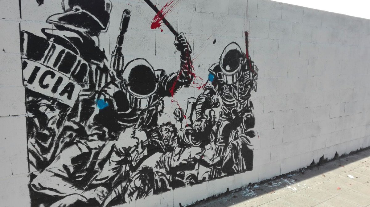 GredaGarrotxa's tweet photo. El mural del #12oct contra la violència policial el dia del referèndum ha estat atacat. Han tapat les banderes espanyoles dels policies https://t.co/nFcFvUdbA6