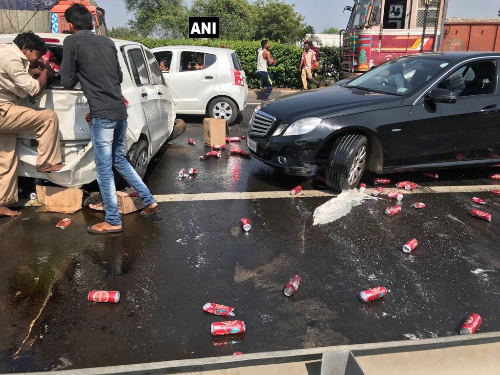 ANI's tweet photo. #Gujarat: Car illegally carrying liquor met with an accident near Dumad in #Vadodara; villagers pounced on the car to loot the cans. https://t.co/llbRIEtTB3