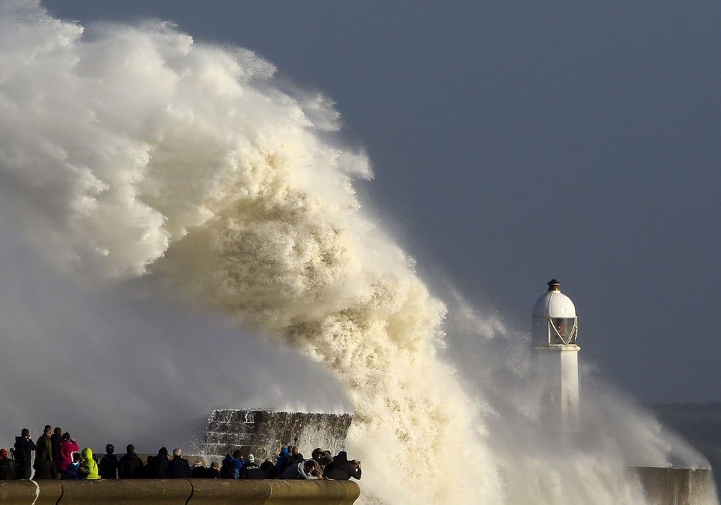 StormHour's tweet image. Huge waves strike the harbour wall and lighthouse at Porthcawl, south Wales: Geoff Caddick buff.ly/2xKgXbt #StormOphelia #StormHour