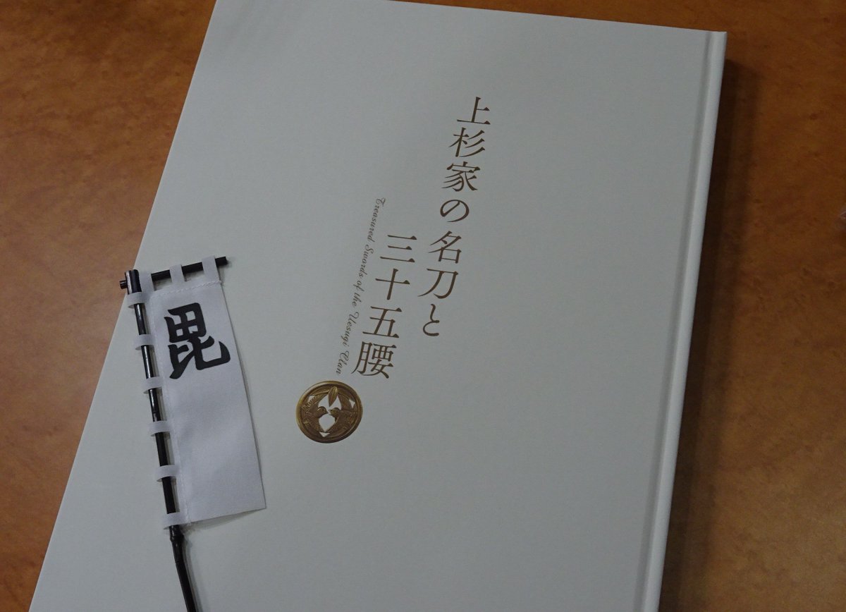 上杉家の名刀と三十五腰」公式図録の表紙に美しい金具の上杉家の紋が