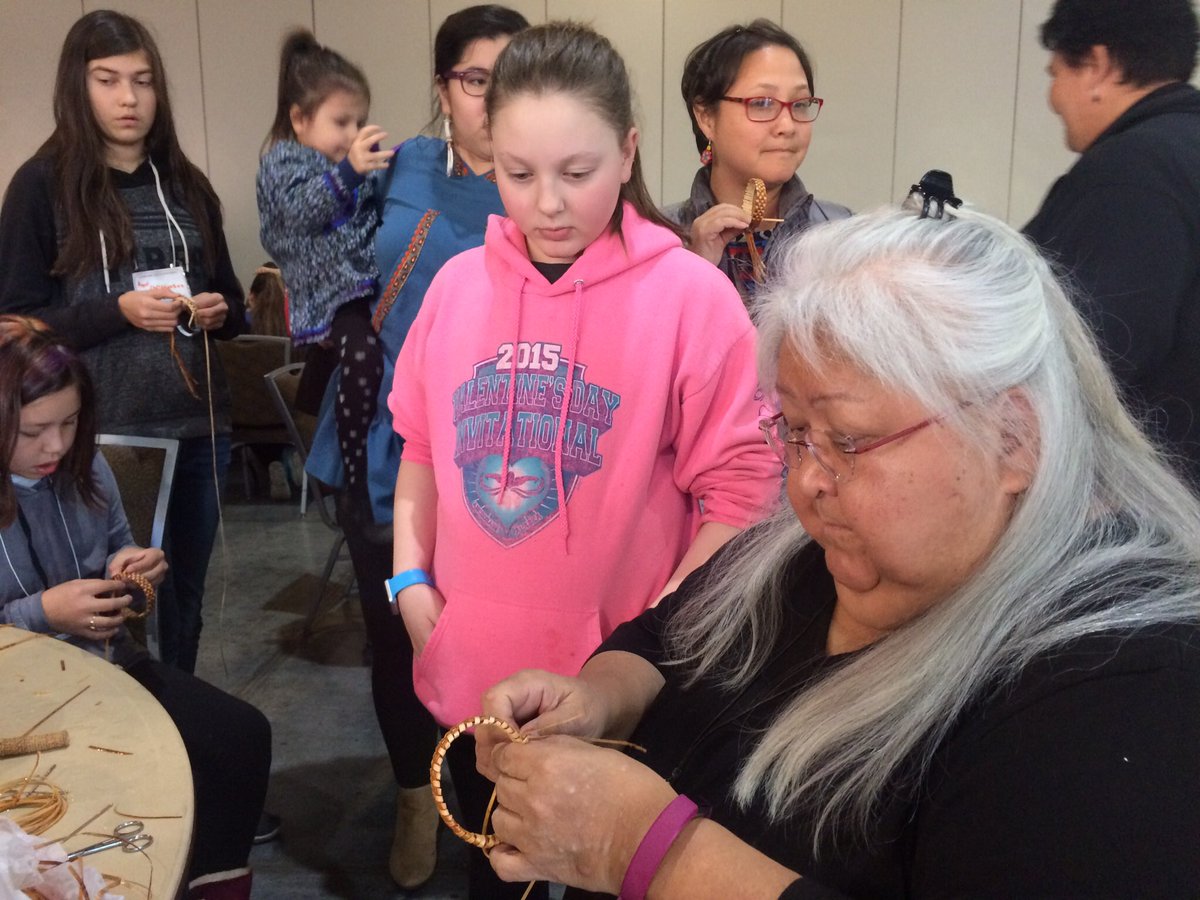 HeatherHintze's tweet photo. Elder Della Cheney shows kids how to weave cedar bark bracelets. It's a unique skill she learned from her grandma in Southeast. #EY2017 https://t.co/9nsXif28BV